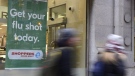 People walk pass a sign for flu shots in Toronto on January 9, 2018. Canada has entered a flu epidemic, the national public health agency said Tuesday, after the test positivity rate nearly doubled in one week. The Public Health Agency of Canada said in its FluWatch report that the rate jumped to 11.7 per cent the week of Oct. 30 to Nov. 5, compared to 6.3 per cent the previous week. The agency declared an epidemic, which happens most years after the threshold of a five per cent positivity rate is surpassed, though it said influenza levels are higher than would have been expected when compared to pre-pandemic years. THE CANADIAN PRESS/Doug Ives