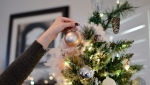 Woman decorating Christmas tree. (Element5 Digital/Pexels)