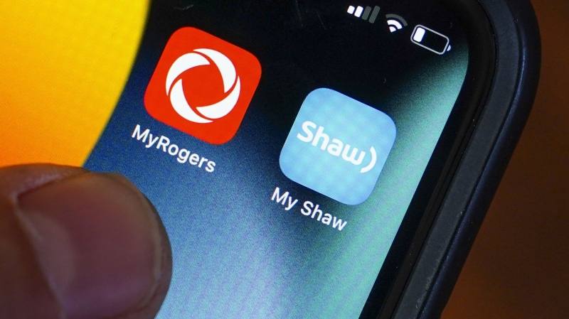 Rogers and Shaw applications are pictured on a cellphone in Ottawa, Monday, May 9, 2022. (THE CANADIAN PRESS/Sean Kilpatrick)