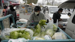 Residents buy fresh vegetables from street vendors as restaurants are closed in some districts in Beijing, Thursday, Nov. 24, 2022. (AP Photo/Ng Han Guan)