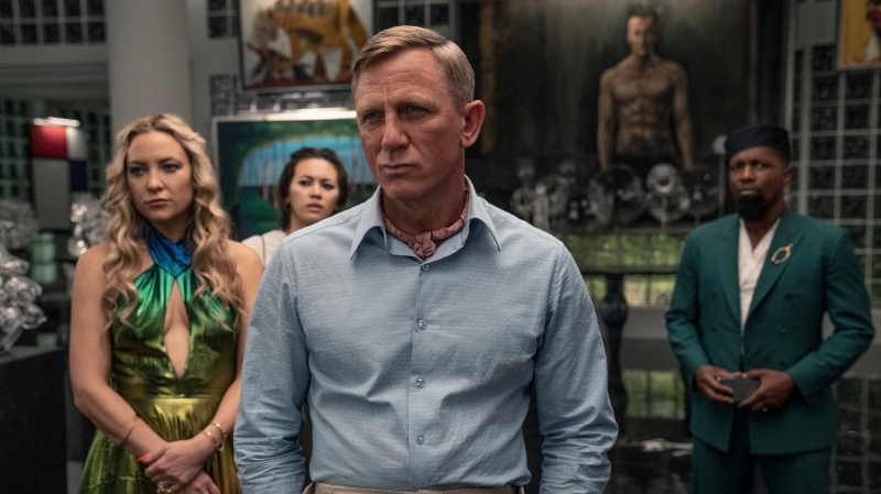 This image released by Netflix shows Kate Hudson, from left, Jessica Henwick, Daniel Craig and Leslie Odom Jr. in a scene from "Glass Onion: A Knives Out Mystery." (John Wilson/Netflix via AP)
