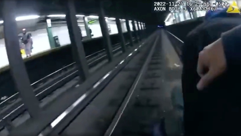 This image provided by NYPD shows police body cam video shows two New York City police officers and a bystander saving a man who fell on the tracks at a Manhattan subway station on Thursday, Nov. 24, 2022 in New York. The incident happened around 4 p.m. Thursday at the 116th Street station in East Harlem. The man, whom police said fell by accident, was taken to a hospital with injuries to his hand and back. (NYPD via AP)