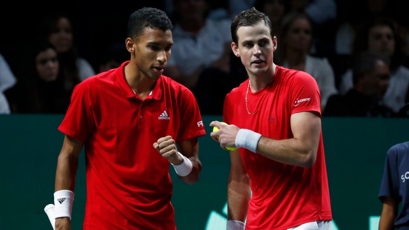 Canada's Vasek Pospisil, right, speaks to Felix Auger Aliassime during the semi-final Davis Cup tennis doubles match between Italy and Canada in Malaga, Spain, Saturday, Nov. 26, 2022. (AP Photo/Joan Monfort)