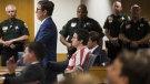 Austin Harrouff, center, wearing stripes, accused of brutally killing a Tequesta couple in 2016, appears Friday, Aug. 2, 2019, at the Martin County Courthouse in Stuart, Fla., as defense attorney Robert Watson, standing in front of Harrouff, asks Martin County Circuit Judge Sherwood Bauer Jr., to not allow video recording of a mental health evaluation to be conducted by a psychologist hired by the state. (Xavier Mascarenas/TCPalm.com via AP, File)