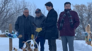 Prime Minister Justin Trudeau visits a gravesite on James Smith Cree Nation. (Lisa Risom/ CTV News)