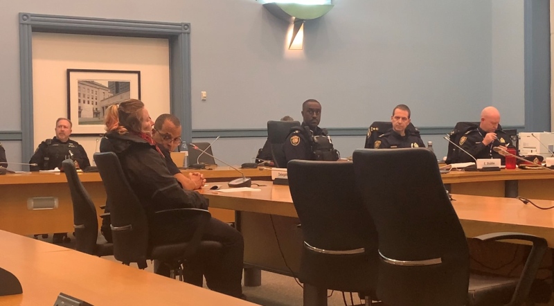 Robin Browne and Bailey Gauthier, seated in the foreground, hold a protest of the Ottawa Police Services Board meeting Monday, Nov. 28, 2022, refusing to leave until their questions are answered. (Jackie Perez/CTV News Ottawa)