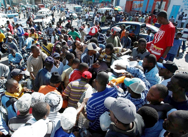People gather around a gas pump seeking gas, Thursday, Jan. 14, 2010, in Port-au-Prince, Haiti. Gas shortage is causing long lines and angry customers. (AP / The Miami Herald, Carl Juste)