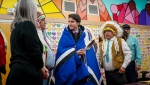 Prime Minister Justin Trudeau, middle receives a blanket from Chakastaypasin Chief Calvin Sanderson, left, and James Smith Cree Nation Chief Wally Burns, right, at James Smith Cree Nation, Sask., on Monday, November 28, 2022. THE CANADIAN PRESS/Heywood Yu 