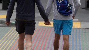 Two men hold hands while walking on a rainbow-coloured crosswalk in San Francisco,on June 27, 2020. (Jeff Chiu / AP) 