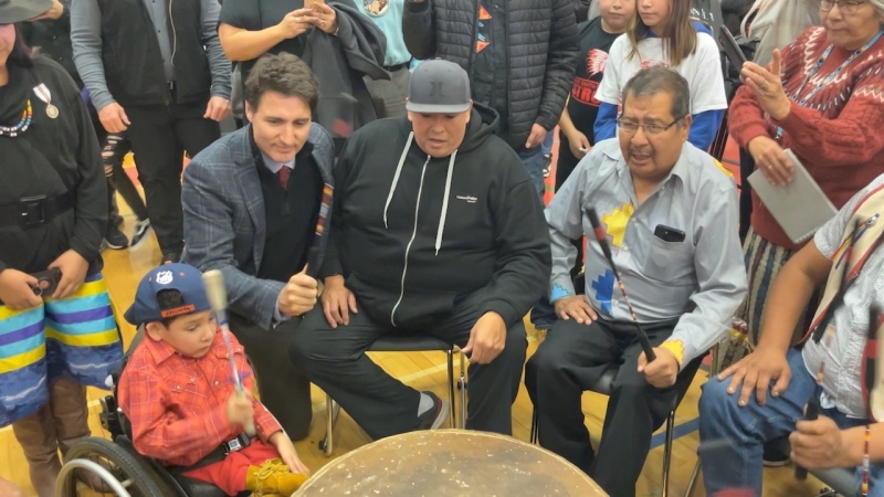 Justin Trudeau joins some drummers for a song during his visit to James Smith Cree Nation on Nov. 28. (Chad Hills / CTV News)