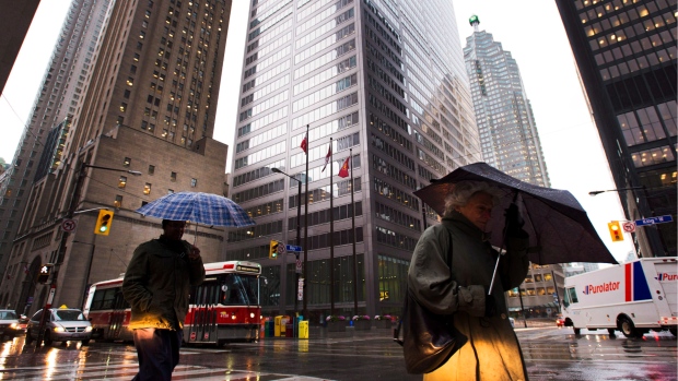 People take cover with their umbrellas in Toronto's financial district as weather worsens in Toronto, Monday, Oct. 29, 2012. THE CANADIAN PRESS/Nathan Denette