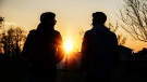 Two men walk side-by-side during sunset. (Stefano Cavoretto/ Adobe)