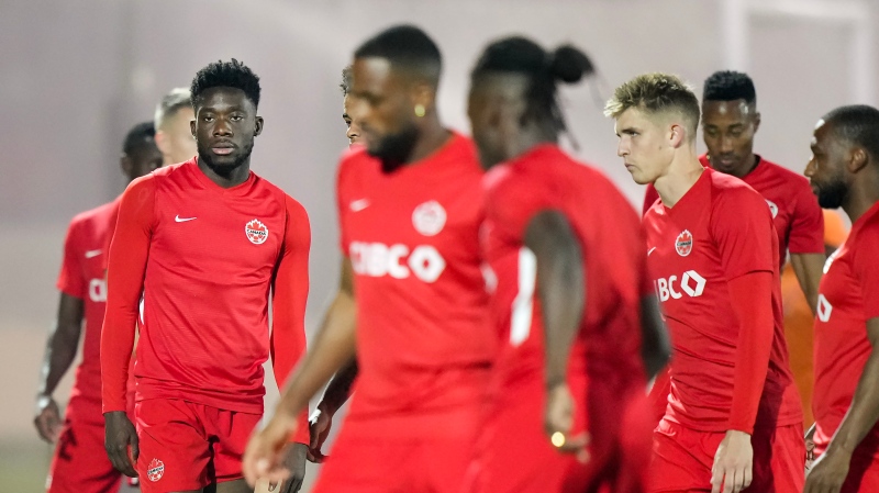 Canada forward Alphonso Davies, left, warms up with teammates during practice at the World Cup in Doha, Qatar on Tuesday, November 29, 2022. THE CANADIAN PRESS/Nathan Denette