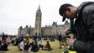 People smoke marijuana on Parliament Hill in Ottawa on April 20, 2019. (Sean Kilpatrick / THE CANADIAN PRESS)