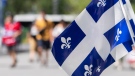 Quebec flags flap in the wind at a walk through installation to celebrate Saint-Jean-Baptiste Day in Montreal on Thursday, June 24, 2021. THE CANADIAN PRESS/Graham Hughes