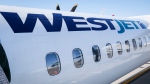 A WestJet plane waits at a gate at Calgary International Airport in Calgary, Alta., Wednesday, Aug. 31, 2022. THE CANADIAN PRESS/Jeff McIntosh