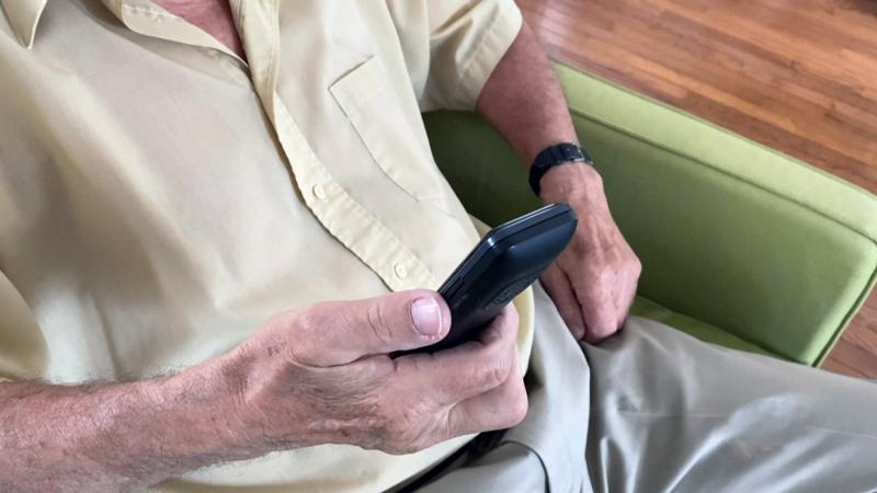 Senior holding phone