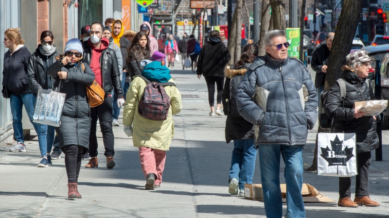 Pedestrians walk down St. Catherine Street, Monday, April 6, 2020 in Montreal. Since the global onset of COVID-19, Canada has been gradually closing the gap with the United States when it comes to attracting and keeping an important economic prize: new permanent residents. (THE CANADIAN PRESS/Ryan Remiorz)