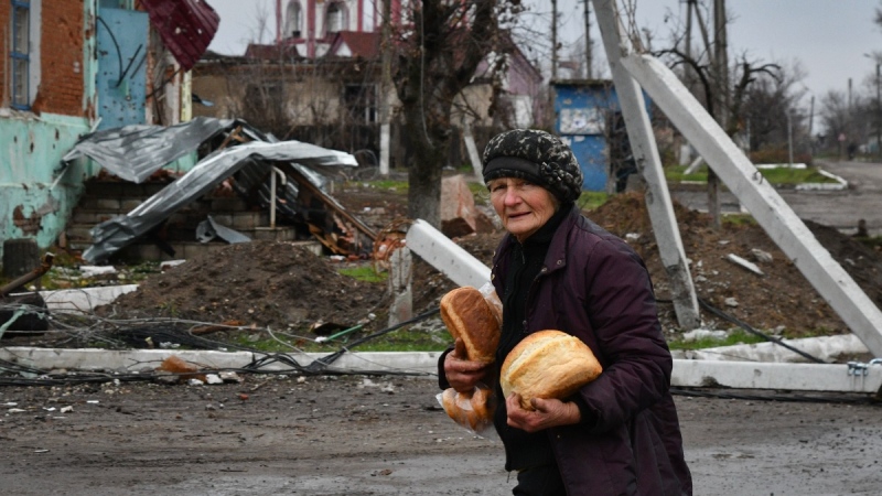 A woman carries bread after receiving it at a humanitarian aid point in the village of Drobysheve, Donetsk region, Ukraine, on Nov. 18, 2022. (Andriy Andriyenko / AP) 