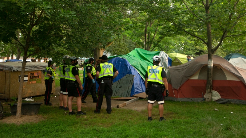 Police and city officials circle tents at a encampment in Toronto, on Tuesday, July 20, 2021. THE CANADIAN PRESS/Chris Young