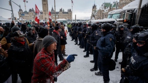 Police move in to clear downtown Ottawa near Parliament hill of protesters after weeks of demonstrations on Saturday, Feb. 19, 2022. THE CANADIAN PRESS/Cole Burston