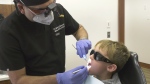 Dr. Neeraj Bansal of Dentistry at Arnprior performs a check up on a 7 year old patient. (Dylan Dyson/CTV News Ottawa) 