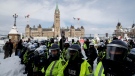 Police push back protesters as authorities work to end a protest against COVID-19 measures that had grown into a broader anti-government demonstration and occupation lasting for weeks, in Ottawa, Saturday, Feb. 19, 2022. THE CANADIAN PRESS/Cole Burston 