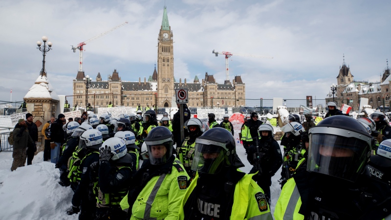 Police push back protesters as authorities work to end a protest against COVID-19 measures that had grown into a broader anti-government demonstration and occupation lasting for weeks, in Ottawa, Saturday, Feb. 19, 2022. THE CANADIAN PRESS/Cole Burston 