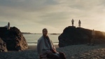 The short film, titled “All is Beauty” was posted to YouTube by Simons and also appeared as shorter commercials. In it, a woman is seen surrounded by people on a beach, in a candle-lit forest, and in other settings with costumed dancers and illuminated fantastical creatures that depict a dream-like summary of a woman’s final days.