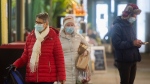 People wear face masks as the walk through a market in Montreal, Wednesday, November 16, 2022. The Quebec government has recommended wearing masks in public spaces. THE CANADIAN PRESS/Graham Hughes