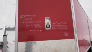 Police conducted 17 search warrants at addresses in Camrose and the surrounding area on Nov. 21, 2022, as part of a "property crime" investigation. A red trailer with writing on it including the word, "stolen," is pictured here. CTV News Edmonton blurred the other information. 