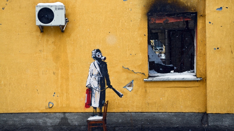 HOSTOMEL, UKRAINE - NOVEMBER 26, 2022 - The mural by England-based street artist Banksy depicts a woman in a gas mask standing on a chair and holding a fire extinguisher, Hostomel, Kyiv Region, northern Ukraine. (Photo credit should read Oleksandra Butova / Ukrinform/Future Publishing via Getty Images)