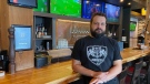 The Lancaster Taphouse owner Tim Rogers poses for a photo at the bar of his restaurant. He is being forced to close his pub after nearly 11 years of operation. (Donovan Maess / CTV News)