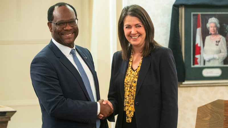 Kaycee Madu shakes hands with Alberta Premier Danielle Smith, in Edmonton, Monday, Oct. 24, 2022. Madu, Alberta’s deputy premier, says the proposed sovereignty bill does not grant cabinet unilateral power to rewrite laws behind closed doors, but amendments may be needed to clear that up. (THE CANADIAN PRESS/Jason Franson)