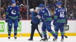 Vancouver Canucks goalie Thatcher Demko, centre, is helped off the ice by a trainer and Ilya Mikheyev (65), of Russia, after being injured as Tyler Myers (57) and Elias Pettersson, of Sweden, watch during the first period of an NHL hockey game against the Florida Panthers in Vancouver, on Thursday, December 1, 2022. THE CANADIAN PRESS/Darryl Dyck