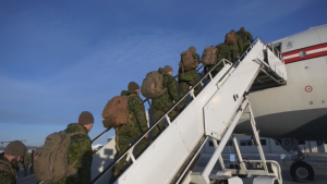 Canadian troops board a plane to Latvia on Dec. 3, 2022. 