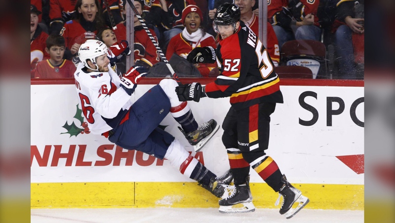 Washington Capitals' Nic Dowd, left, is knocked down by Calgary Flames' MacKenzie Weegar during first period NHL hockey action in Calgary, Ab., Saturday, Dec. 3, 2022. THE CANADIAN PRESS/Larry MacDougal
Larry MacDougal