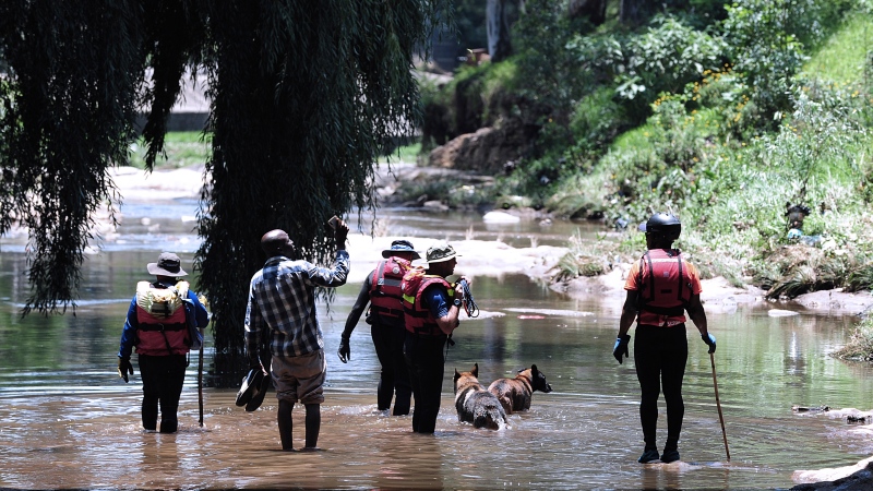 Rescue workers search the waters of the Jukskei river in Johannesburg on Dec. 4, 2022. At least nine people have died while eight others are still missing in South Africa after they were swept away by a flash flood along the Jukskei river in Johannesburg, rescue officials said Sunday. (AP Photo)
