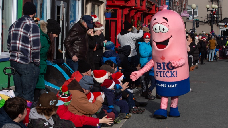 The Maple Leaf Big Stick Balogna interacts with a people during the St. John's Downtown Christmas Parade in St. John's on Sunday December 4, 2022. The Maple Leaf Foods Mr. Big Stick mascot is a waving, walking, cylindrical stick of bologna -- complete with a top knot -- which has been a staple of the city's parade for over 25 years.  (THE CANADINA PRESS/Paul Daly)