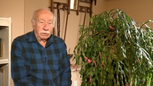 Art Isner sits in his home next to a 100-year-old Christmas cactus that's been cared for by the Eisner family for generations.