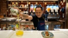 A bartender prepares a drink in a restaurant in the 22-decks cruise ship MSC World Europa, a floating hotel docked at Doha Port to offer accommodate for around 6,700 World Cup fans, in Doha, Qatar, Sunday, Nov. 13, 2022. Final preparations are being made for the soccer World Cup which starts on Nov. 20 when Qatar face Ecuador. (AP Photo/Hassan Ammar)
