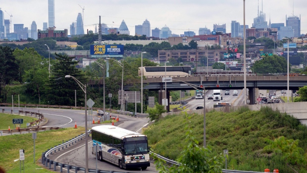 A bus exits Route 495 and heads to the New Jersey Turnpike, Thursday, June 21, 2018. The New York City skyline is in the distance. (AP Photo/Mark Lennihan)
