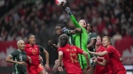 Canada goalkeeper Stephanie Labbe, centre right, punches the ball away from Nigeria's Christy Ucheibe, centre left, during the first half of a women's friendly soccer match in Vancouver on April 8, 2022. THE CANADIAN PRESS/Darryl Dyck