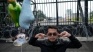 An activist plugs his ears during a protest in front of the parliament building in Jakarta, Indonesia, Tuesday, Dec. 6, 2022. Indonesia's Parliament passed a long-awaited and controversial revision of its penal code Tuesday that criminalizes extramarital sex for citizens and visiting foreigners alike. (AP Photo/Achmad Ibrahim) 
