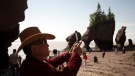 A tourist stops to take a photo of the Hopewell Rocks on the Bay of Fundy, N.B., Friday, August, 16, 2013. (THE CANADIAN PRESS/Jonathan Hayward)