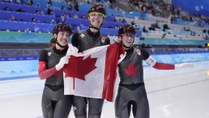 Team Canada's Valerie Maltais, left, Isabelle Weidemann and Ivanie Blondin, right, pose with the Canadian flag after winning the gold medal and setting an Olympic record in the speedskating women's team pursuit at the 2022 Winter Olympics, Tuesday, Feb. 15, 2022, in Beijing. (THE CANADIAN PRESS/AP-Sue Ogrocki)