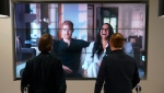 Office workers in London, watch the Duke and Duchess of Sussex's controversial documentary being aired on Netflix Thursday, Dec. 8, 2022. (Jonathan Brady/PA via AP)