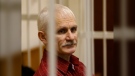 FILE - Ales Bialiatski, the head of Belarusian Viasna rights group, stands in a defendants' cage during a court session in Minsk, Belarus, on Nov. 2, 2011. Activist Ales Bialiatski, who shared the 2022 Nobel Peace Prize with human rights groups in Russia and Ukraine, is the fourth person in the 121-year history of the Nobel Prizes to receive the peace award while in prison or detention. (AP Photo/Sergei Grits, File)