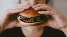An image of someone holding a burger. In 2022, a Torontonian spent over $1,000 on Uber Eats from unknown burger joint. (Pexels/Szabó Viktor)