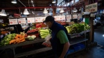 A person shops for produce at the Granville Island Market in Vancouver, on Wednesday, July 20, 2022. THE CANADIAN PRESS/Darryl Dyck